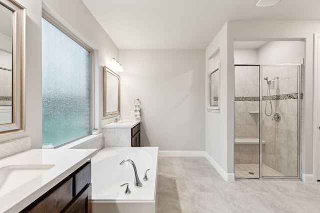 bathroom with a shower stall, a bath, baseboards, and two vanities