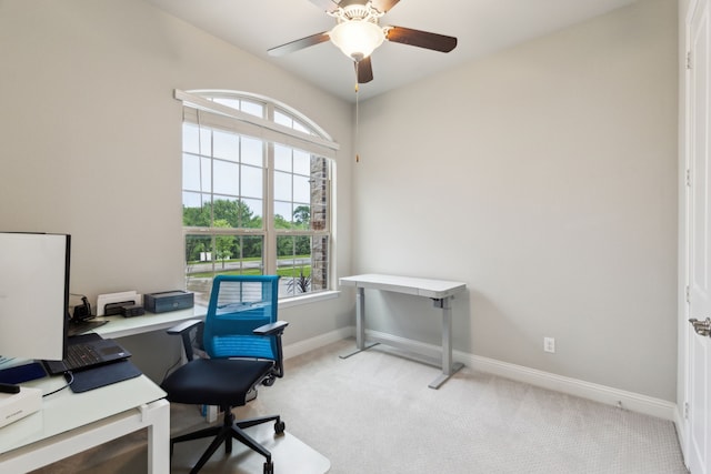 office featuring light carpet, a ceiling fan, and baseboards