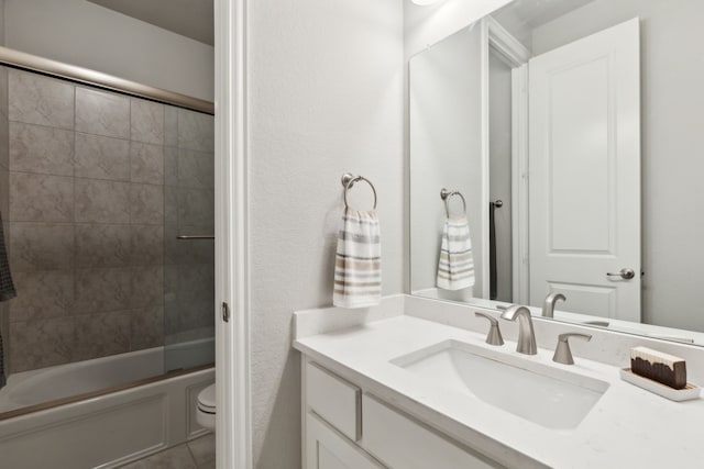 full bathroom with toilet, vanity, and bath / shower combo with glass door