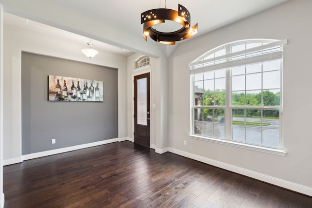 foyer entrance with dark wood finished floors and baseboards