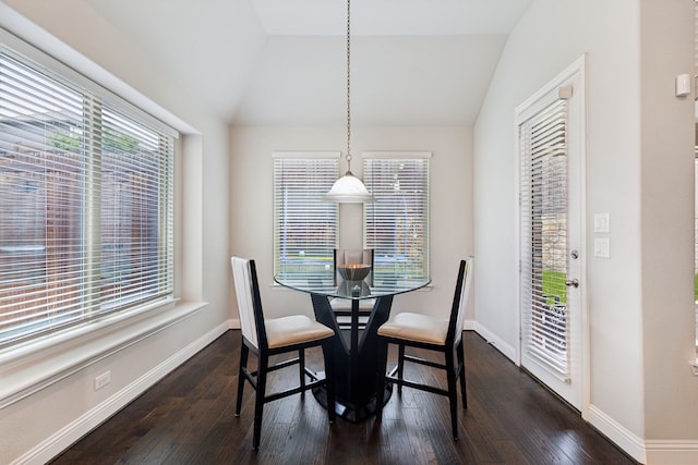 dining room featuring dark wood finished floors, lofted ceiling, and baseboards
