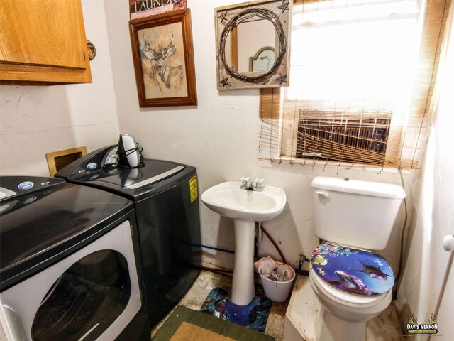 bathroom featuring toilet and washer and clothes dryer