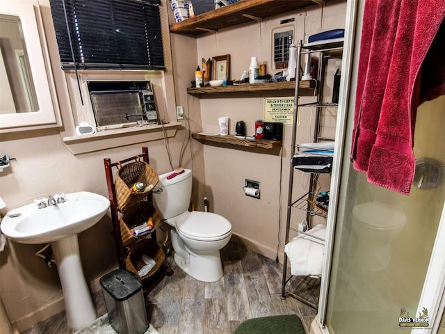full bathroom featuring wood finished floors, a shower stall, toilet, a sink, and baseboards
