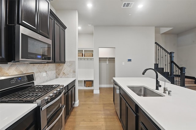 1331 Bailey Ln, Allen, TX 75013 - kitchen with light wood finished floors, a sink, stainless steel appliances, visible vents, and light countertops