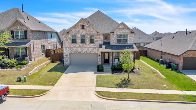 view of front facade featuring a front yard, driveway, brick siding, an attached garage, and fence