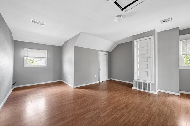 bonus room featuring baseboards, visible vents, and wood finished floors