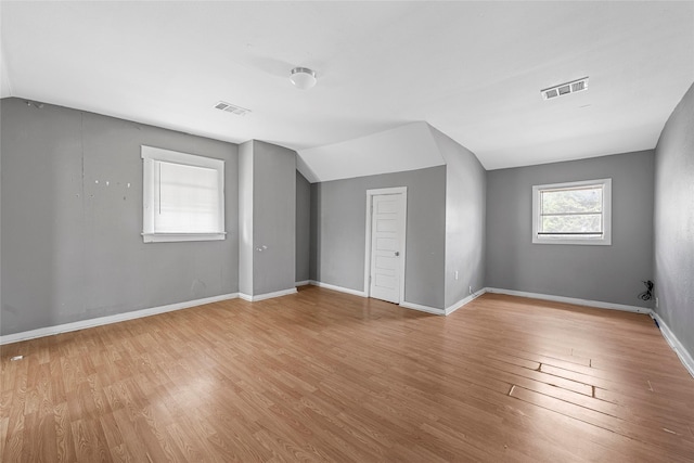 bonus room with visible vents, vaulted ceiling, wood finished floors, and baseboards