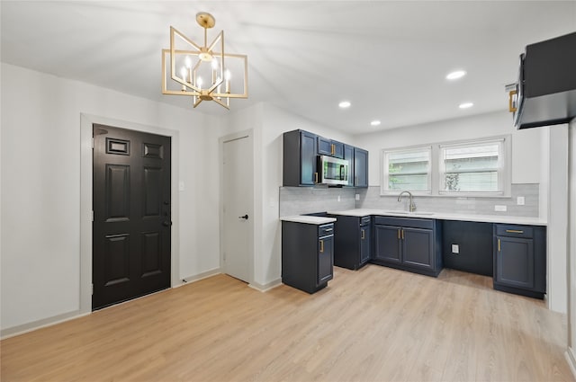 kitchen featuring light wood-type flooring, backsplash, and stainless steel microwave
