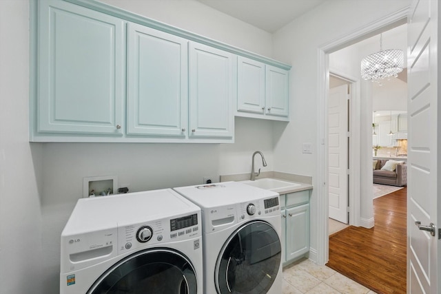 741 Almeda Ln, Prosper, TX 75078 - laundry room featuring cabinet space, washing machine and clothes dryer, a chandelier, and light wood-style floors