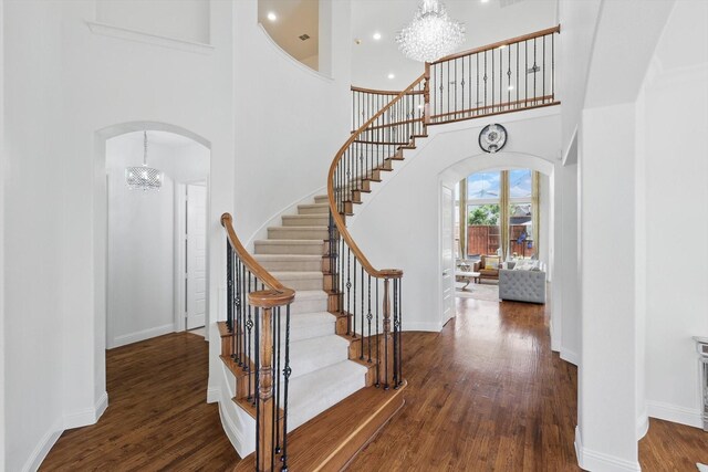 741 Almeda Ln, Prosper, TX 75078 - entrance foyer with arched walkways, a chandelier, wood finished floors, a high ceiling, and stairs