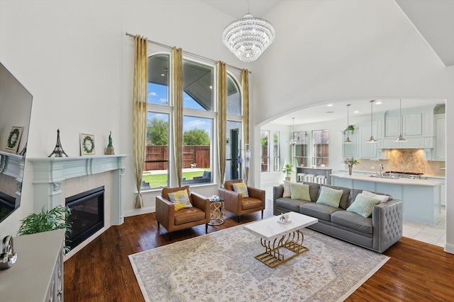 741 Almeda Ln, Prosper, TX 75078 - living area with a chandelier, arched walkways, wood finished floors, and a high ceiling