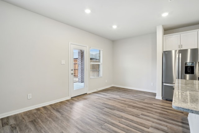 419 Bertney Dr, Princeton, TX 75071 - kitchen with light stone counters, white cabinets, recessed lighting, stainless steel refrigerator with ice dispenser, and wood finished floors