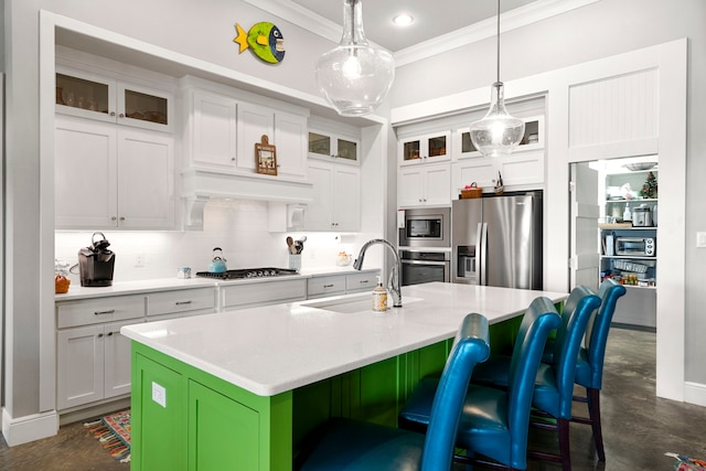kitchen with finished concrete floors, crown molding, a sink, appliances with stainless steel finishes, and a center island with sink