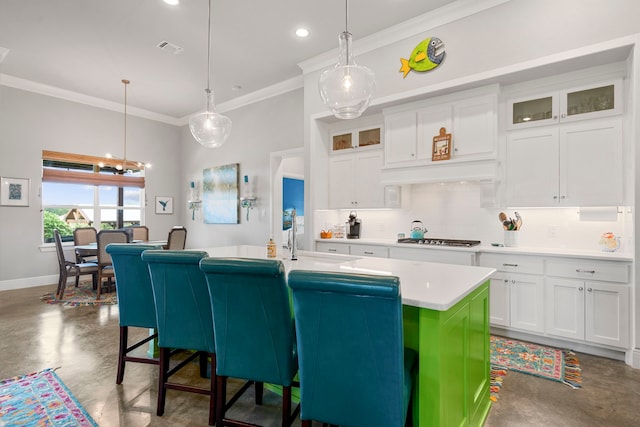 kitchen featuring ornamental molding, concrete flooring, white cabinetry, and light countertops