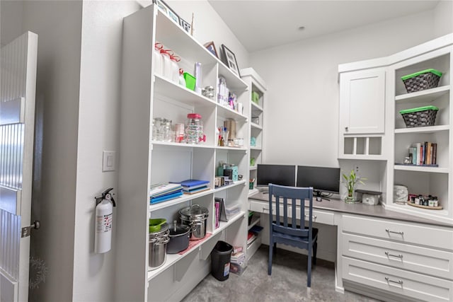 office space with concrete floors and built in study area