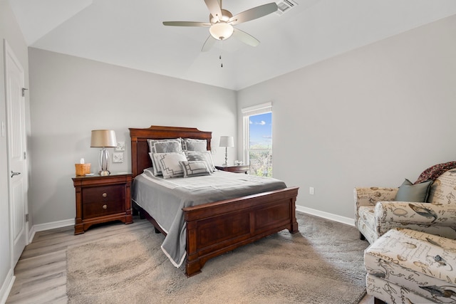 bedroom featuring visible vents, a ceiling fan, light wood finished floors, and baseboards