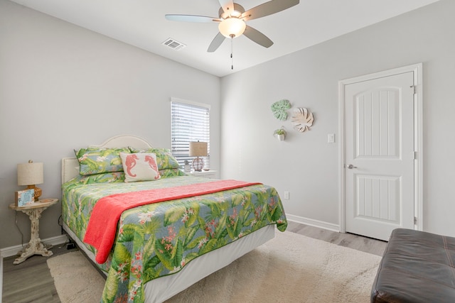 bedroom with baseboards, visible vents, wood finished floors, and ceiling fan