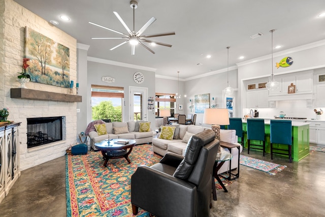 living area with crown molding, ceiling fan, finished concrete flooring, and a fireplace