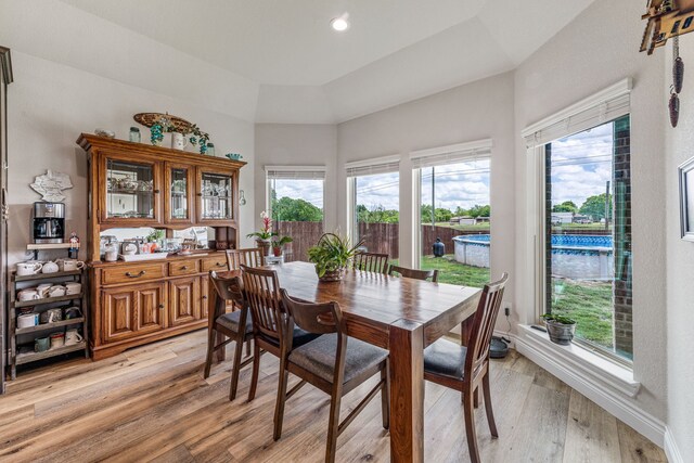 dining room with recessed lighting, a towering ceiling, light wood-style floors, and plenty of natural light