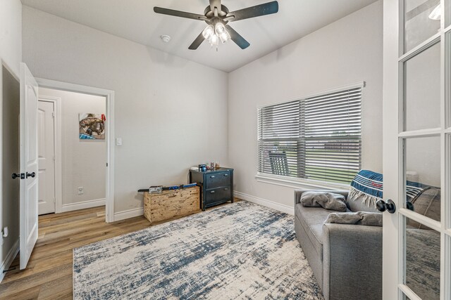 sitting room featuring baseboards, wood finished floors, and ceiling fan
