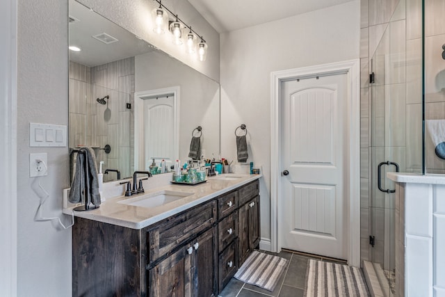 bathroom featuring a stall shower, tile patterned flooring, and a sink