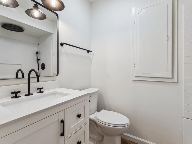 full bath featuring toilet, a shower, wood finished floors, and vanity