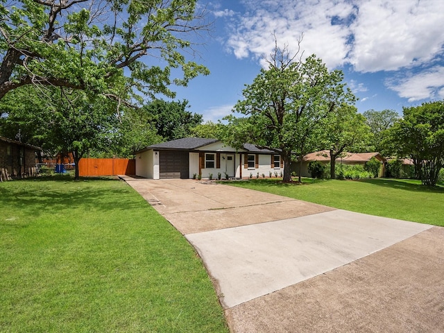 single story home with a front lawn, driveway, an attached garage, and fence