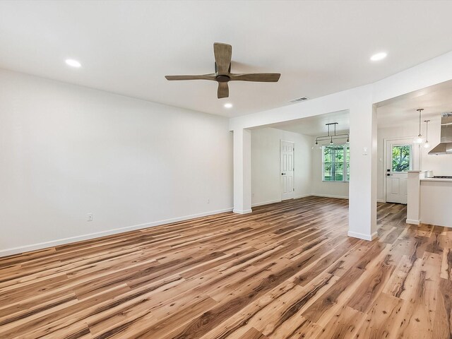 unfurnished living room with recessed lighting, light wood finished floors, a ceiling fan, visible vents, and baseboards