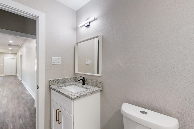 1500 W Collin, Corsicana, TX 75110 - half bathroom with vanity, wood finished floors, toilet, and baseboards