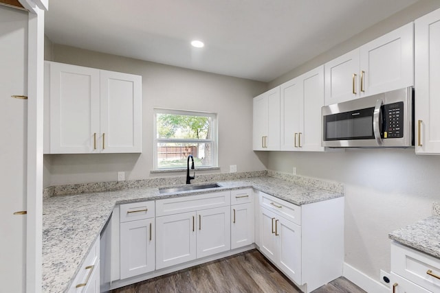 1500 W Collin, Corsicana, TX 75110 - kitchen with stainless steel microwave, a sink, white cabinets, and recessed lighting
