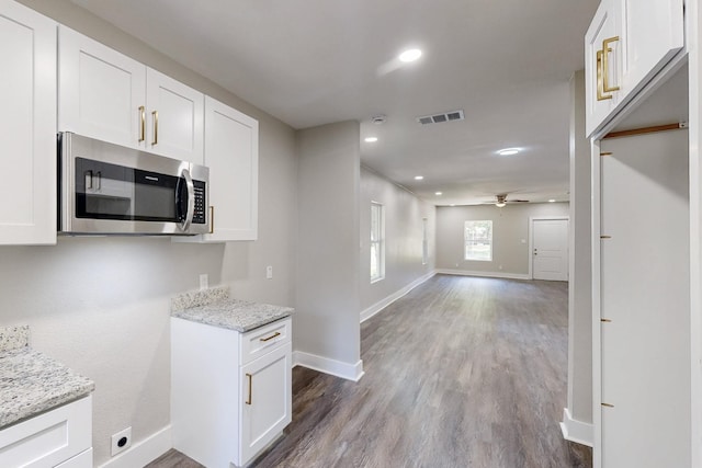 1500 W Collin, Corsicana, TX 75110 - kitchen with stainless steel microwave, open floor plan, baseboards, light stone countertops, and recessed lighting