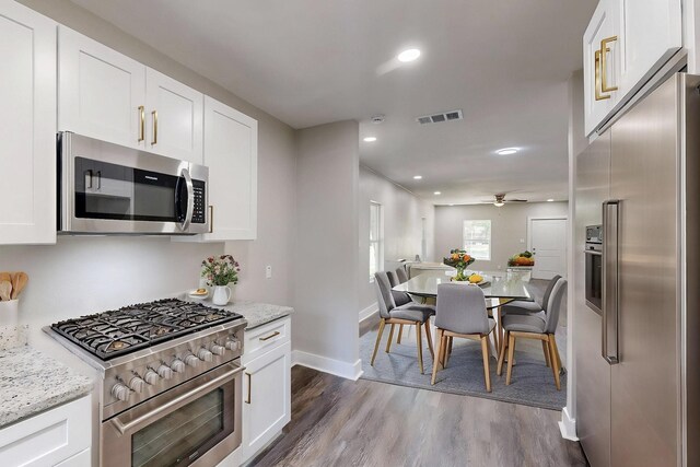 1500 W Collin, Corsicana, TX 75110 - kitchen with high end appliances, dark wood-type flooring, a ceiling fan, baseboards, and white cabinets