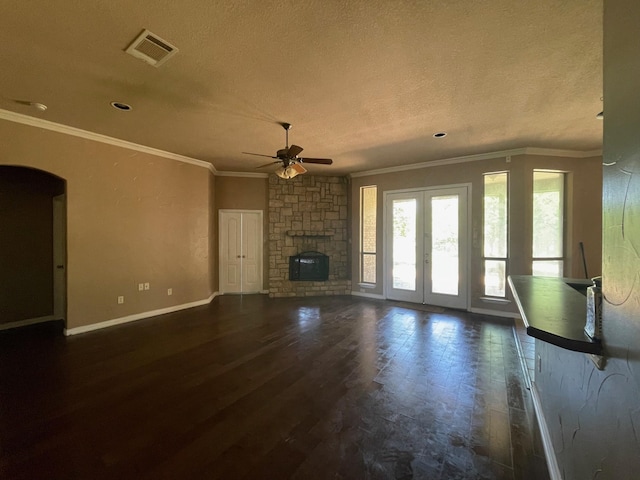 125 Rattling Antler Ct, Azle, TX 76020 - unfurnished living room with ceiling fan, a textured ceiling, dark wood finished floors, a stone fireplace, and visible vents