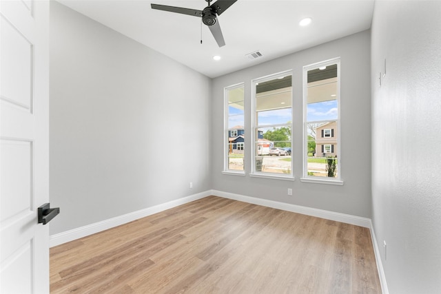 spare room featuring light wood-style floors, baseboards, and a ceiling fan