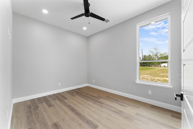 empty room featuring baseboards, ceiling fan, wood finished floors, and visible vents