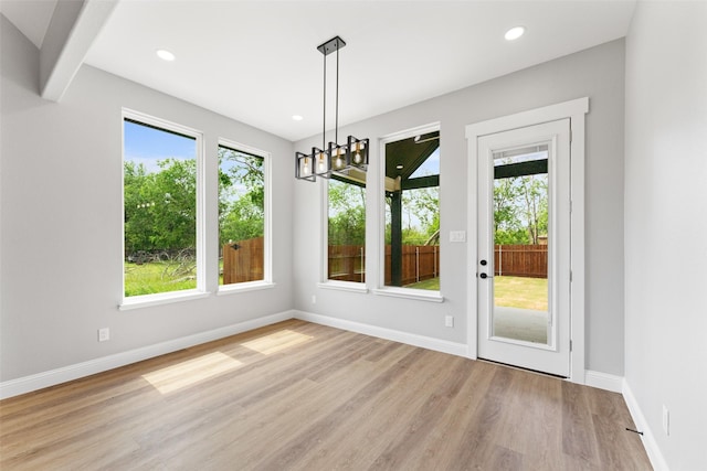 unfurnished dining area featuring recessed lighting, baseboards, a chandelier, and light wood finished floors