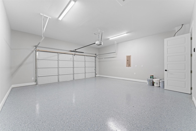 garage with baseboards, a garage door opener, and electric panel