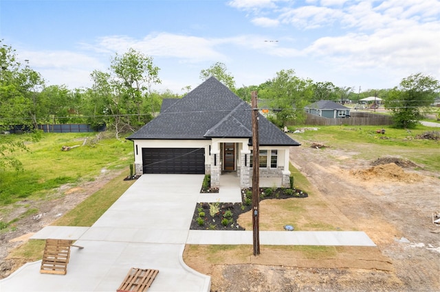 french provincial home with fence, concrete driveway, an attached garage, a shingled roof, and stone siding