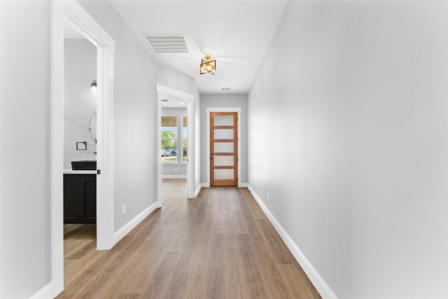 interior space with visible vents, light wood-style floors, and baseboards