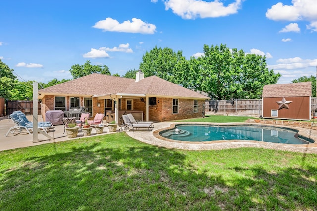 view of pool featuring a patio, a storage unit, and an outbuilding