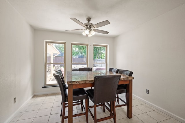 dining area featuring ceiling fan, baseboards, and light tile patterned floors