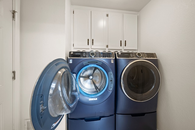 washroom with independent washer and dryer and cabinet space