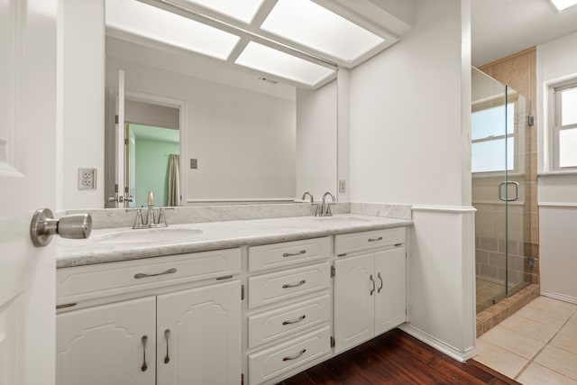 bathroom with a stall shower and double vanity