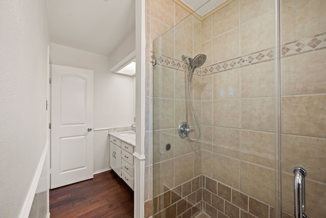 full bath featuring hardwood / wood-style flooring, a stall shower, and vanity