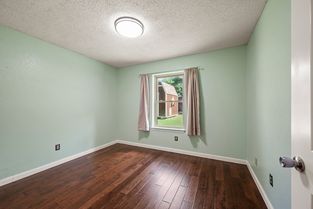 unfurnished room featuring dark wood finished floors, baseboards, and a textured ceiling