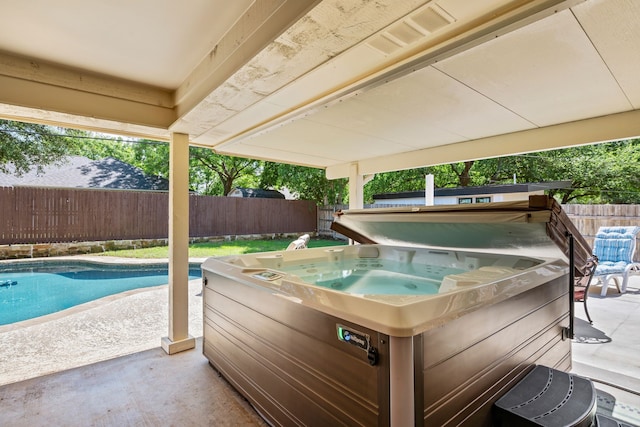 view of swimming pool featuring a hot tub, a fenced backyard, and a patio