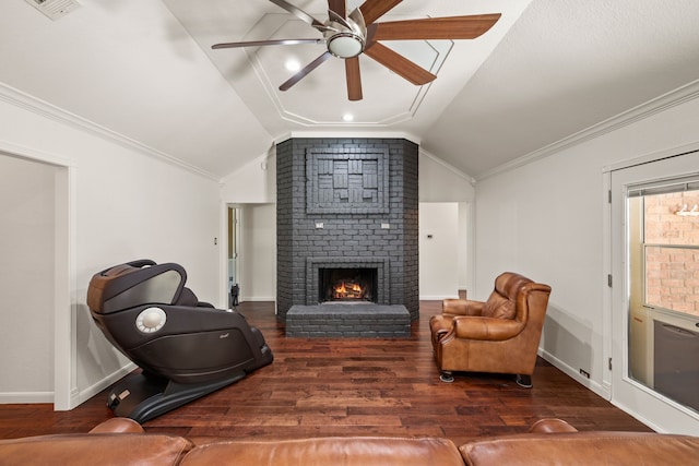 sitting room featuring lofted ceiling, ceiling fan, wood finished floors, ornamental molding, and a brick fireplace