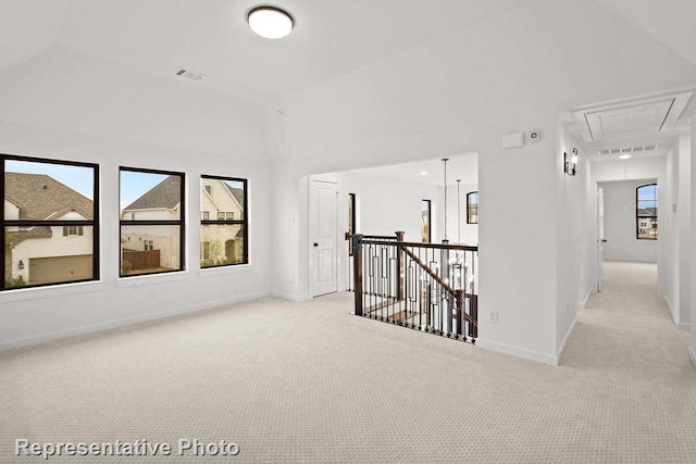 unfurnished room featuring attic access, visible vents, light carpet, and baseboards