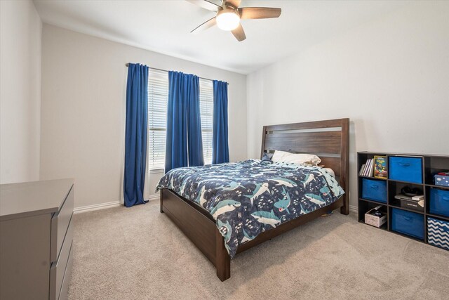 bedroom featuring light colored carpet, baseboards, a closet, and a ceiling fan