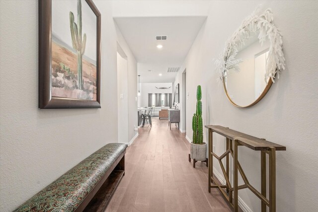 kitchen featuring stainless steel appliances, baseboards, a sink, decorative backsplash, and wood finished floors